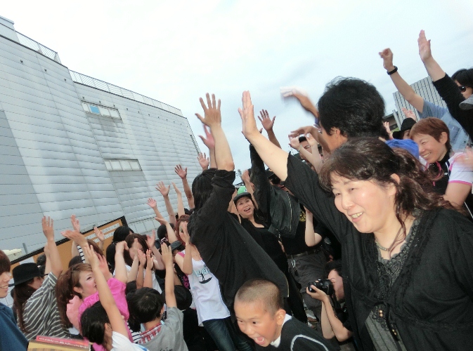 空に向かって手を挙げる参加者の写真